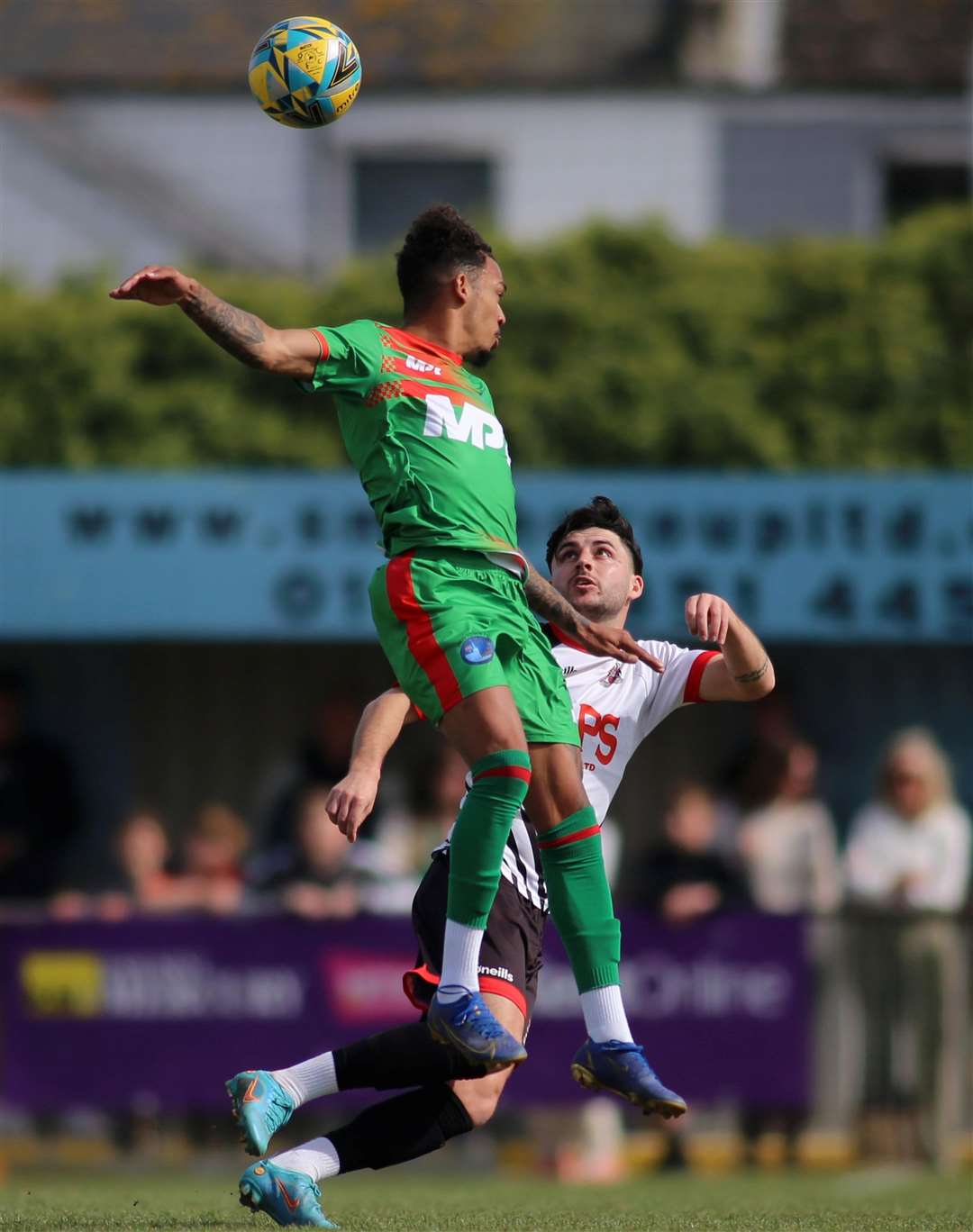 Troy Howard, of Lydd, jumps high as Deal defender Jack Penny pays close attention during the Lyddders’ 3-1 weekend defeat. Picture: Paul Willmott